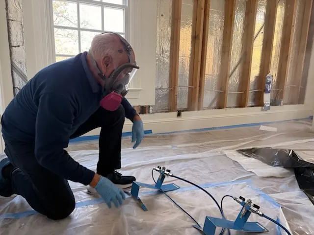 A restoration technician setting drying equipment in a Dallas home stripped to the studs